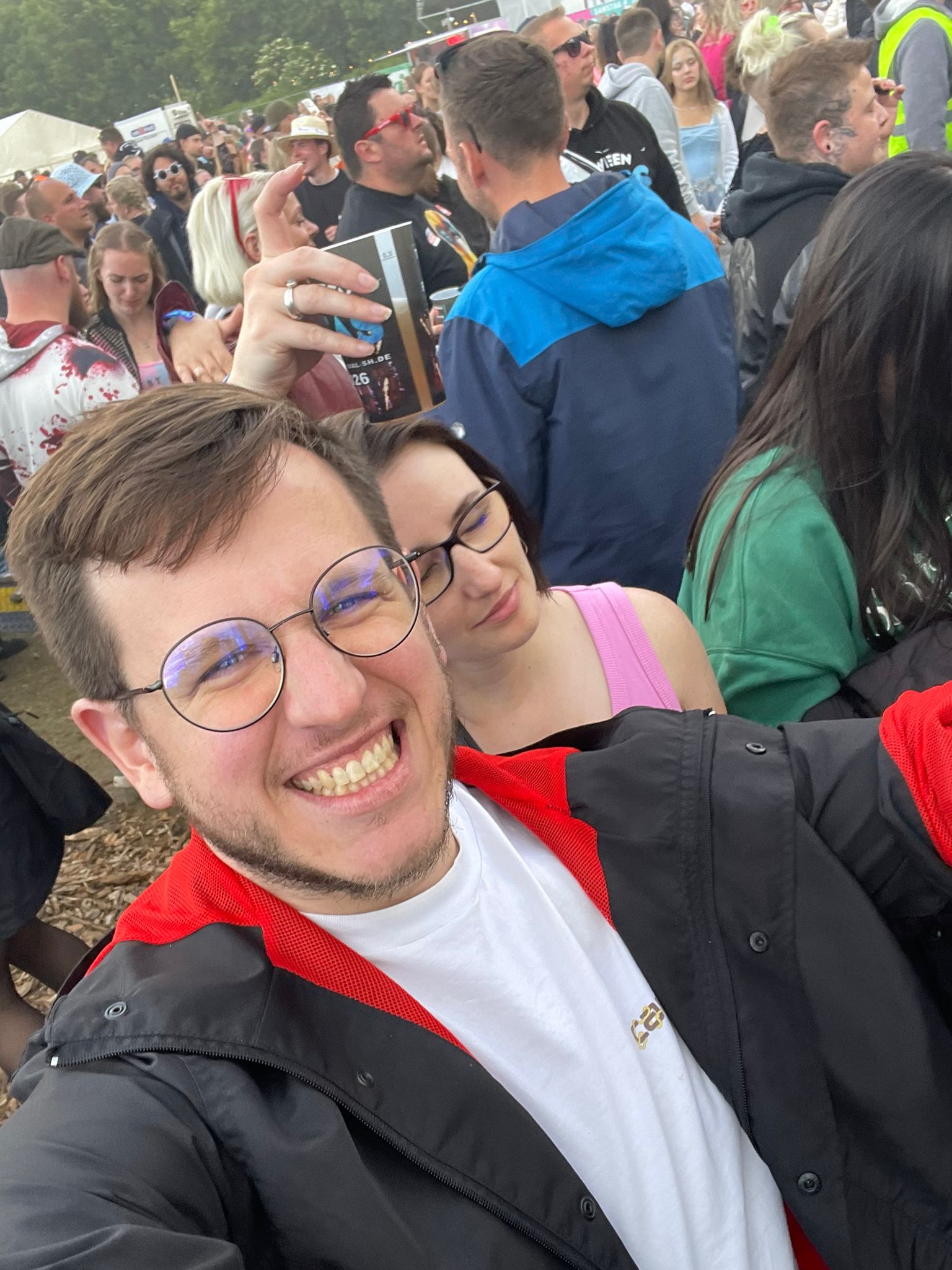 Marek, lächelnd mit runder Brille auf einem Festival
